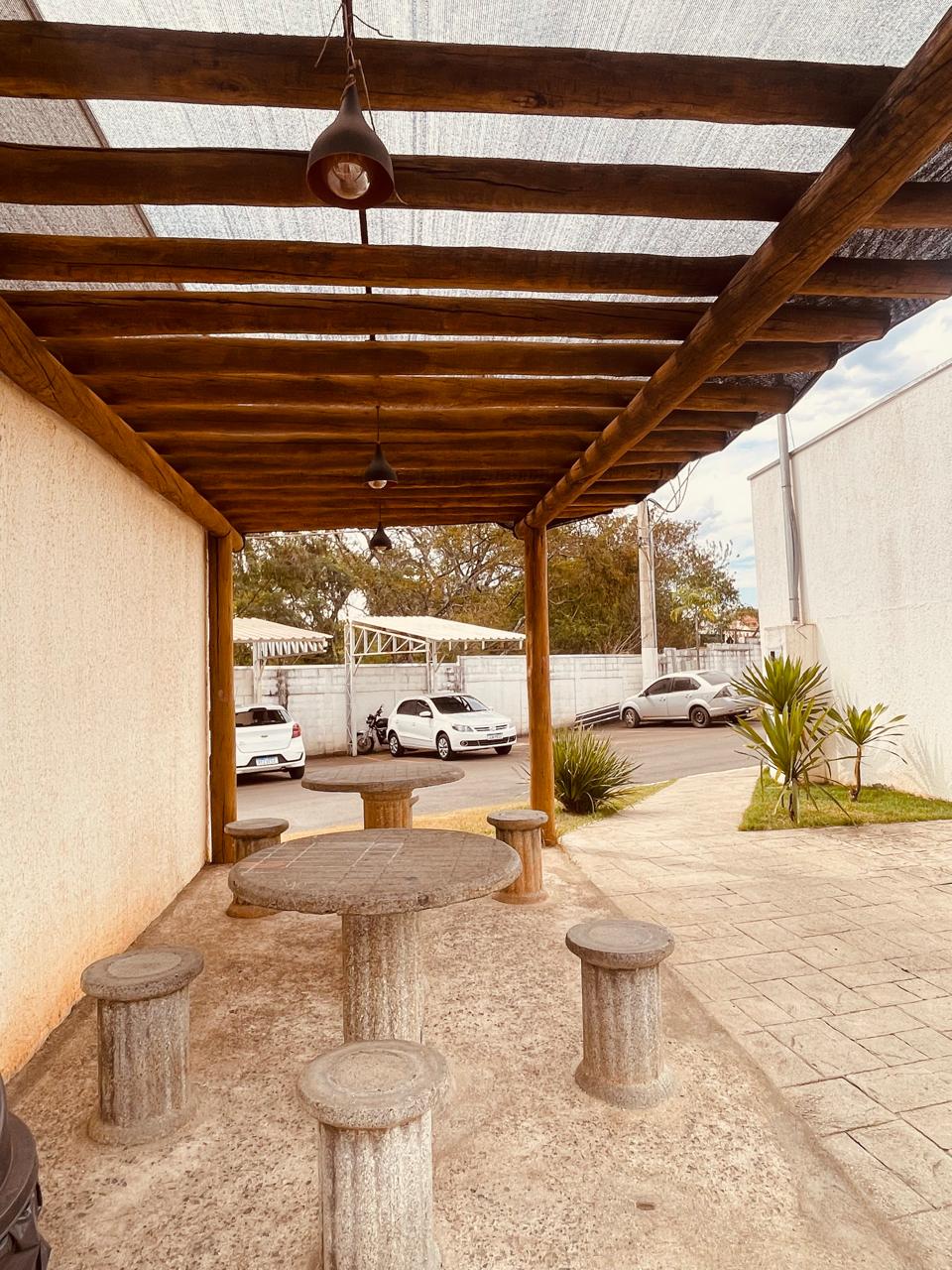 Quiosque com pergola de madeira, mesas e bancos de pedra